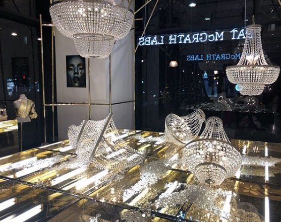 Kroonluchter-installatie in de etalage van Selfridges: kroonluchters op een goudspiegel sokkel